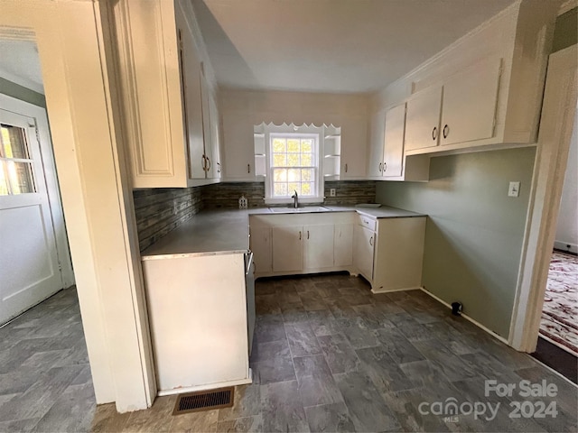 kitchen featuring decorative backsplash, sink, and white cabinetry