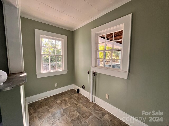 704 Mcadenville Rd, Lowell, NC 28098 - empty room with baseboards, ornamental molding, and dark stone finish floors