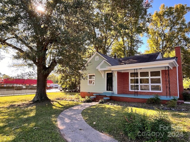 704 Mcadenville Rd, Lowell, NC 28098 - single story home with a porch, a chimney, brick siding, and roof with shingles