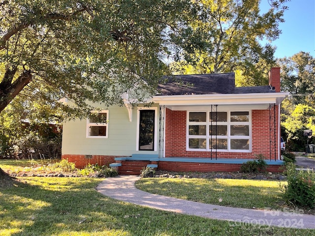 704 Mcadenville Rd, Lowell, NC 28098 - view of front facade with a chimney, a front lawn, and brick siding