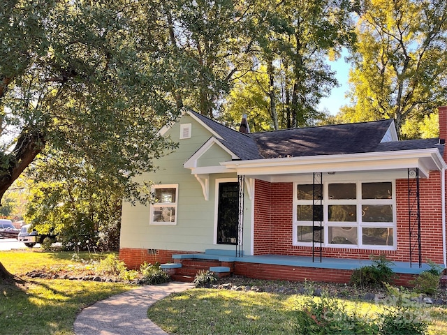 704 Mcadenville Rd, Lowell, NC 28098 - view of front of house with roof with shingles, covered porch, and a front lawn