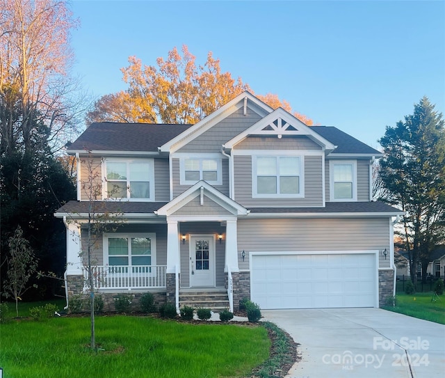 craftsman house with a porch, a garage, and a front yard