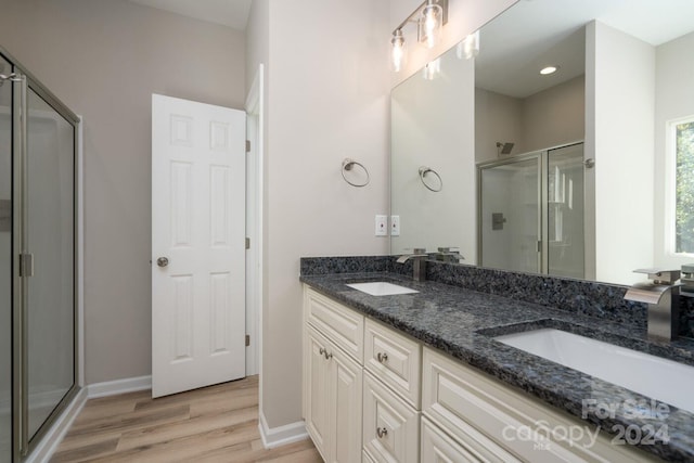 bathroom with vanity, an enclosed shower, and hardwood / wood-style flooring