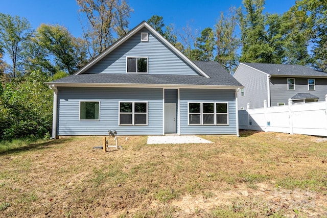 rear view of house featuring a yard