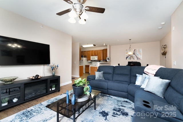 living room featuring light hardwood / wood-style flooring and ceiling fan