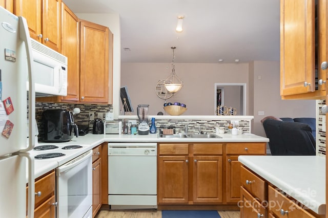 kitchen featuring pendant lighting, white appliances, sink, decorative backsplash, and kitchen peninsula