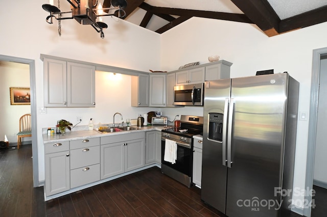 kitchen with beamed ceiling, sink, gray cabinetry, stainless steel appliances, and dark hardwood / wood-style flooring