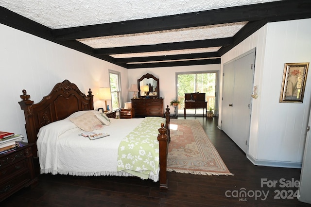 bedroom with dark hardwood / wood-style floors and beamed ceiling