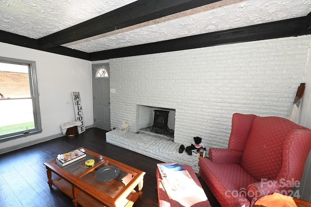 living room with brick wall, beamed ceiling, dark wood-type flooring, and a textured ceiling