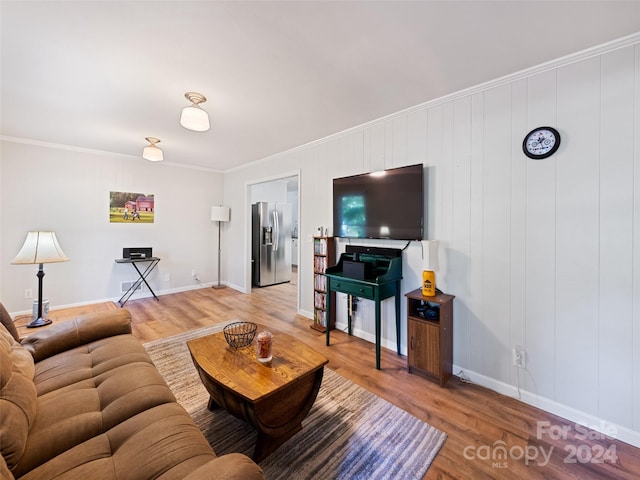 living room with crown molding, hardwood / wood-style flooring, and wooden walls