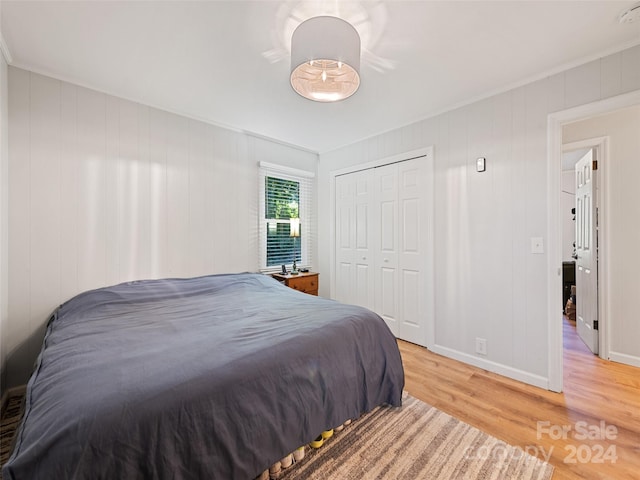 bedroom featuring ornamental molding, a closet, and hardwood / wood-style floors