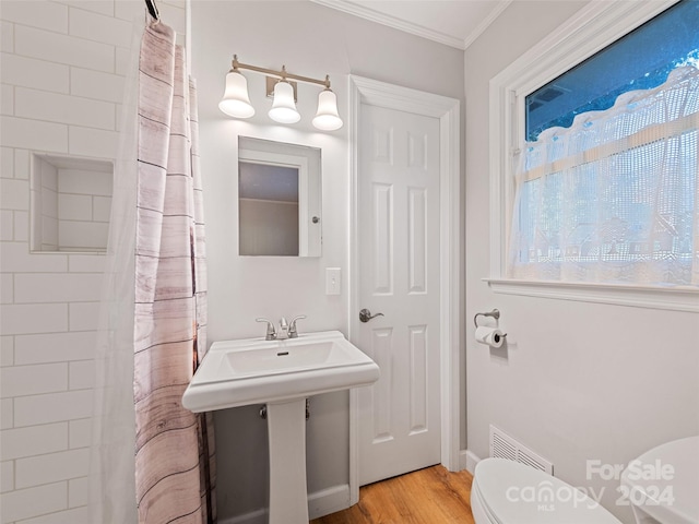 bathroom featuring hardwood / wood-style floors, crown molding, toilet, and a shower with curtain