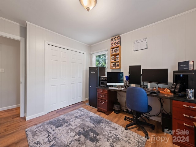 home office with light hardwood / wood-style flooring and ornamental molding