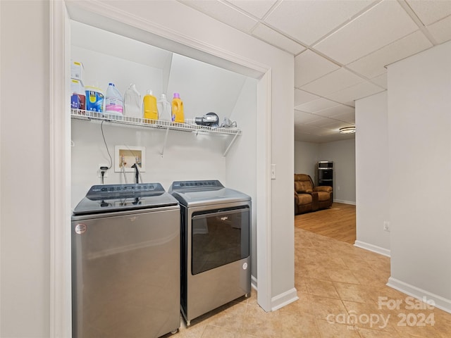 clothes washing area featuring light tile patterned floors and washing machine and clothes dryer