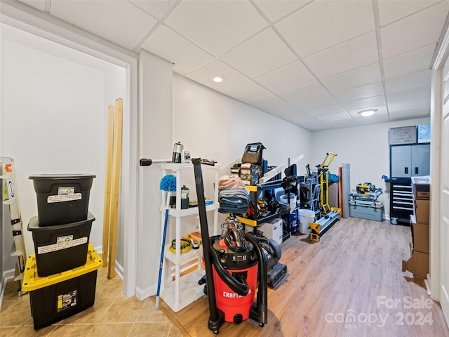 workout area featuring a drop ceiling and hardwood / wood-style floors