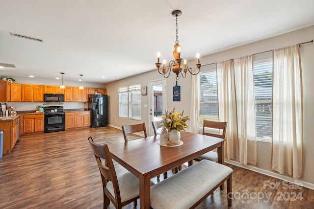 dining room with hardwood / wood-style floors, a notable chandelier, and a healthy amount of sunlight