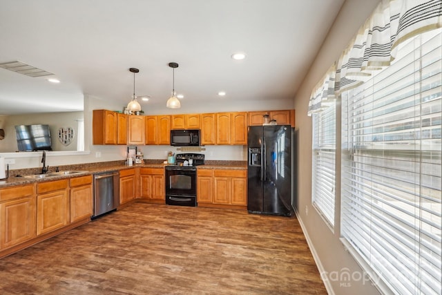 kitchen featuring dark wood-type flooring, black appliances, sink, and a healthy amount of sunlight