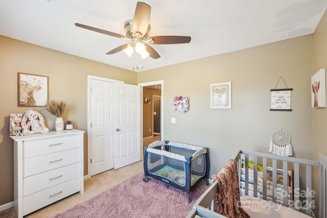 carpeted bedroom featuring ceiling fan and a closet