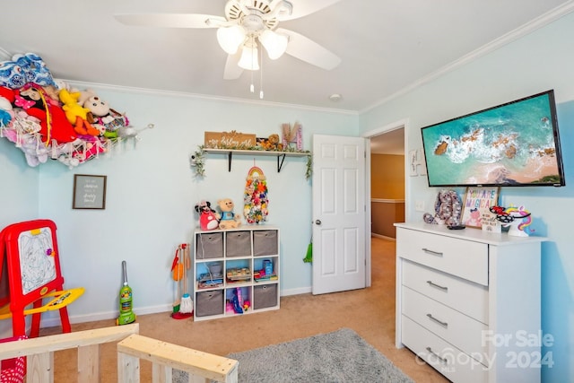 bedroom featuring a nursery area, ornamental molding, light colored carpet, and ceiling fan