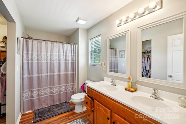 bathroom with hardwood / wood-style floors, toilet, vanity, and a shower with shower curtain