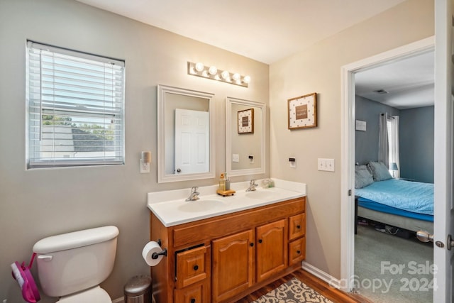 bathroom featuring wood-type flooring, vanity, and toilet