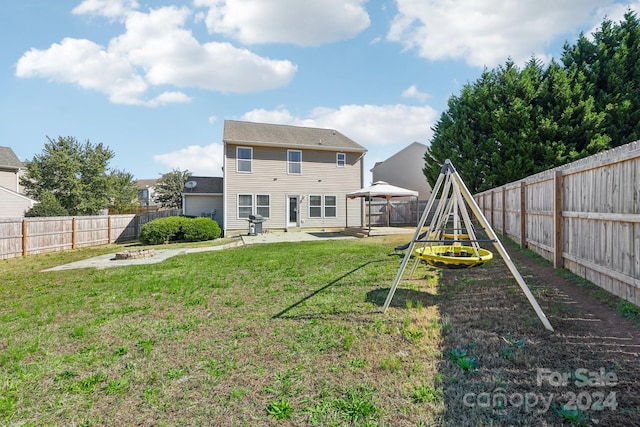 rear view of property featuring a playground, a gazebo, a patio, and a lawn