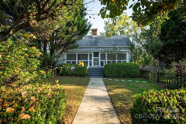 view of front of property with a sunroom and a front lawn