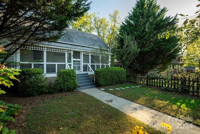 view of front of property with a front yard and a sunroom