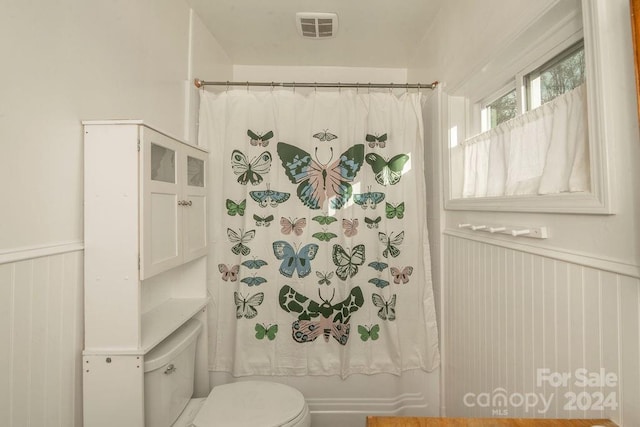 bathroom featuring shower / tub combo and toilet