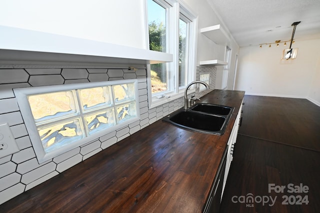 kitchen featuring pendant lighting, a textured ceiling, hardwood / wood-style floors, and sink