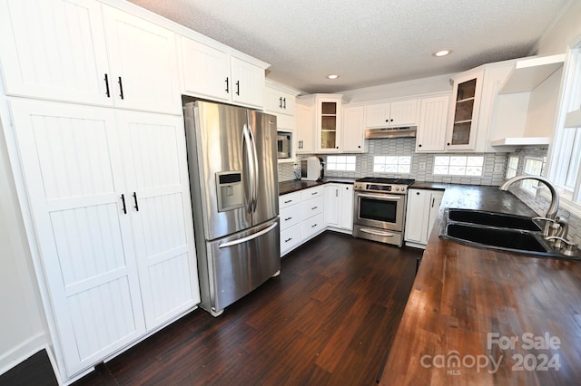 kitchen featuring stainless steel appliances, dark hardwood / wood-style floors, sink, and white cabinetry