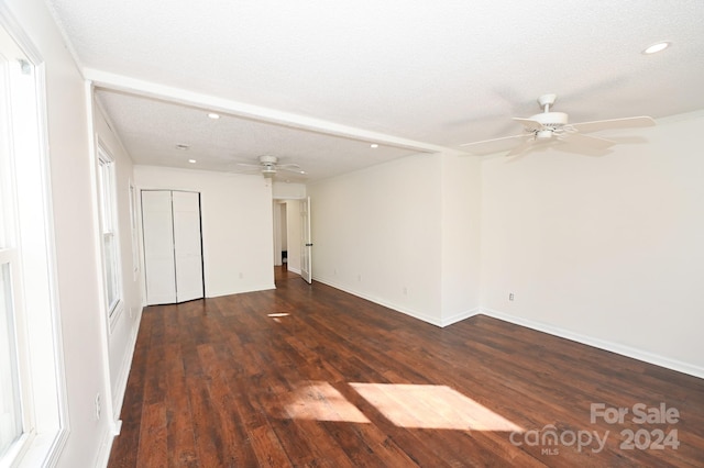 unfurnished room with ceiling fan, a textured ceiling, and dark hardwood / wood-style flooring