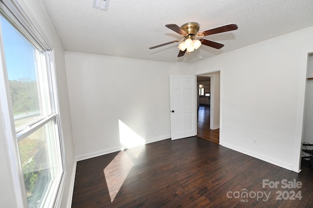 spare room with dark wood-type flooring, ceiling fan, and a textured ceiling