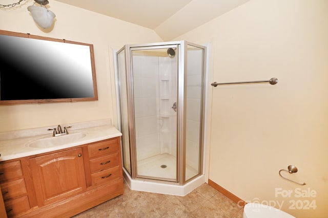 bathroom featuring tile patterned floors, toilet, vanity, and a shower with shower door