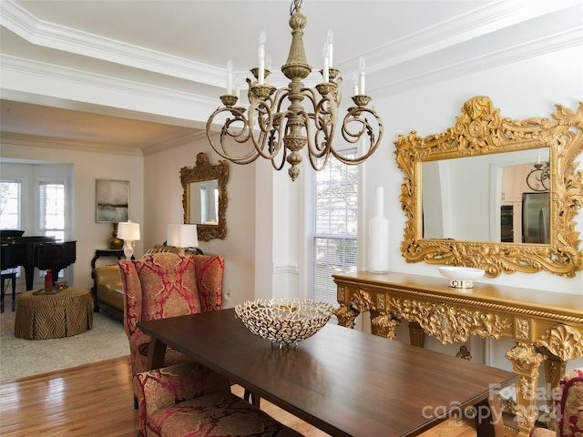 dining space featuring hardwood / wood-style floors, an inviting chandelier, and ornamental molding