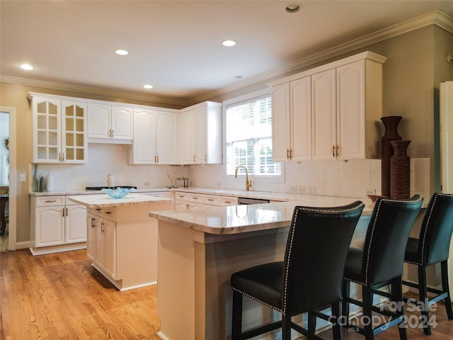 kitchen with white cabinets, a kitchen island, and light hardwood / wood-style flooring