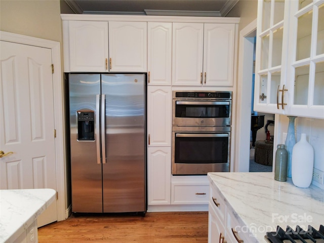 kitchen with light stone countertops, white cabinets, and appliances with stainless steel finishes