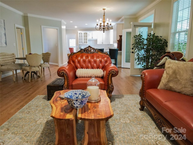 living room featuring an inviting chandelier, light hardwood / wood-style flooring, and ornamental molding