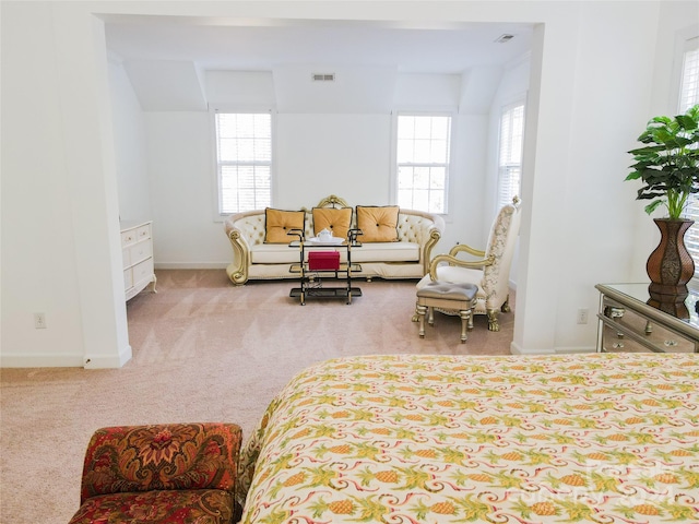 bedroom featuring light carpet and multiple windows