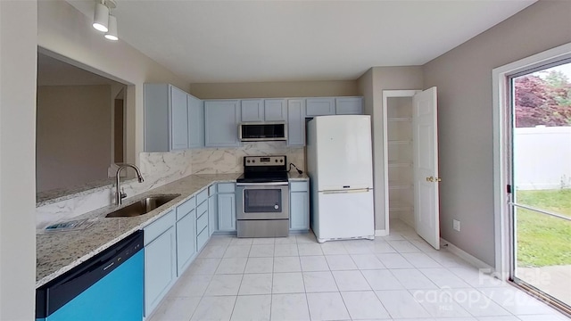 8403 Spirea Ct, Charlotte, NC 28215 - kitchen with light stone counters, decorative backsplash, appliances with stainless steel finishes, a sink, and light tile patterned flooring