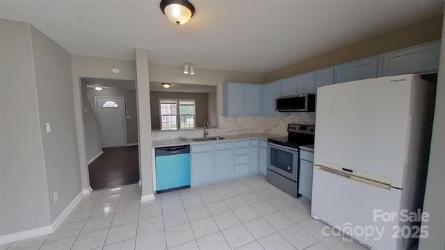 8403 Spirea Ct, Charlotte, NC 28215 - kitchen with light tile patterned floors, a sink, stainless steel appliances, light countertops, and backsplash