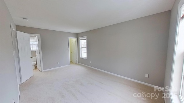 8403 Spirea Ct, Charlotte, NC 28215 - unfurnished bedroom with baseboards, connected bathroom, and carpet