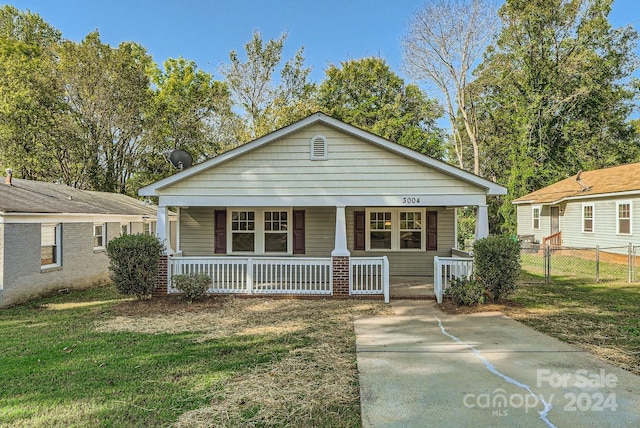 bungalow-style house with covered porch and a front lawn