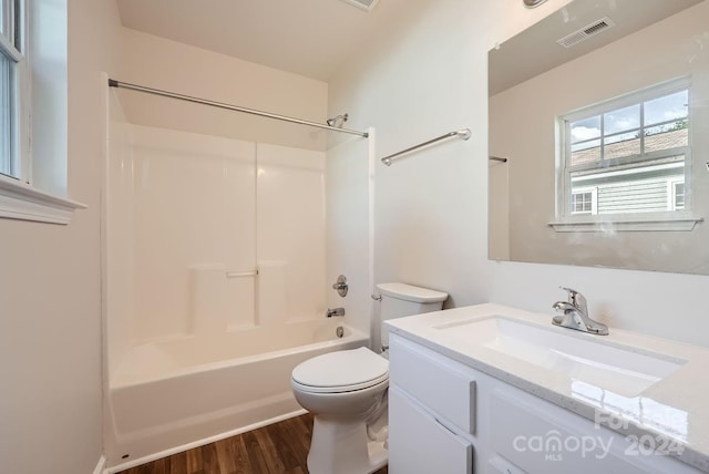 full bathroom featuring toilet, hardwood / wood-style floors, vanity, and washtub / shower combination