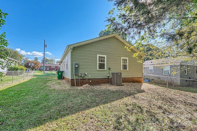 rear view of property featuring a yard and central AC unit