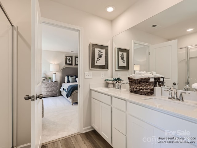 bathroom featuring hardwood / wood-style floors, walk in shower, and vanity