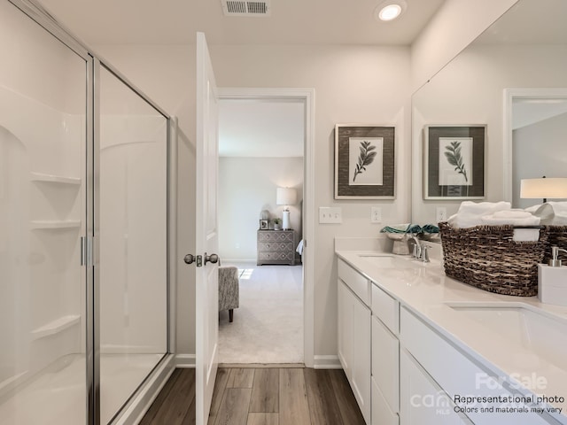 bathroom with a shower with shower door, wood-type flooring, and vanity