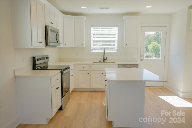 kitchen featuring a kitchen island, white cabinetry, sink, and stainless steel appliances