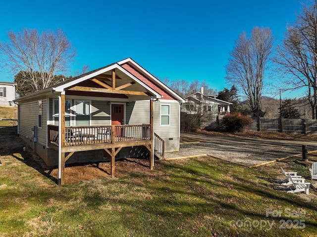 back of property featuring a wooden deck and a lawn