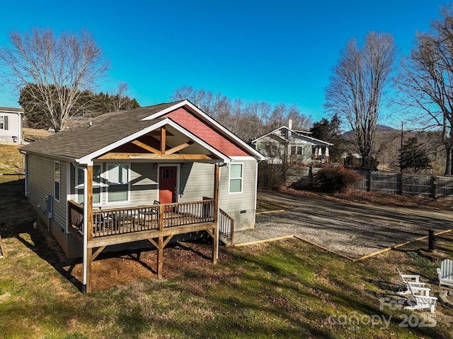 back of property featuring a wooden deck and a yard